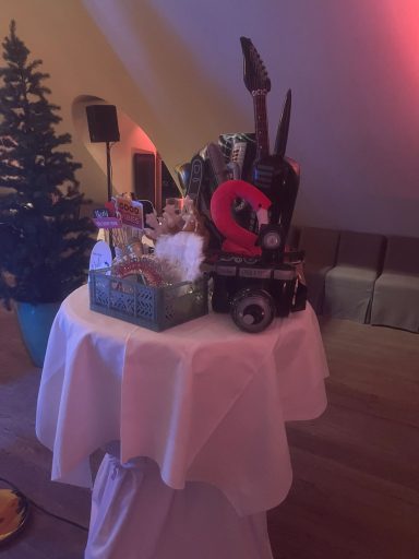 Requisiten Winterhochzeit Dekorierter Tisch mit Küchenutensilien und Geschenken, umgeben von einem Weihnachtsbaum.